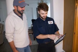 HVAC technician showing trenchless sewer camera inspection results to homeowner on iPad in San Francisco